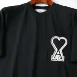 Czarna koszulka z logo serca i literą "A" od firmy AMI Paris.