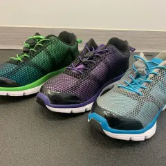 Trzy kolorowe buty sportowe z siateczką i sznurówkami. Idealne, gdy szukasz jakie buty na płaskostopie dla dorosłego.
