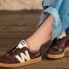 Brązowe buty damskie z krokodylim wzorem i beżowym logo "Wonders" świetnie komponują się z jeansami.