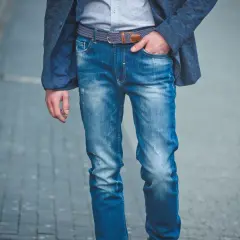 Mężczyzna w niebieskiej marynarce i modnych jeansach, prezentujący różne rodzaje spodni męskich.