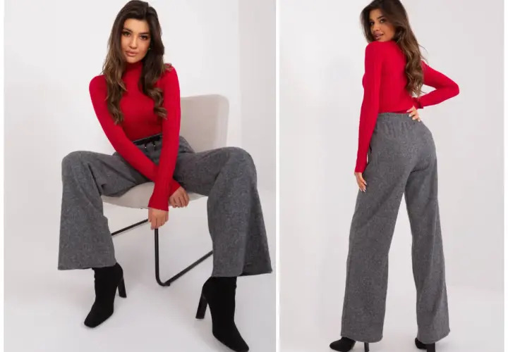 Eleganckie szerokie spodnie damskie w stylizacji z czerwonym golfem i czarnymi botkami.