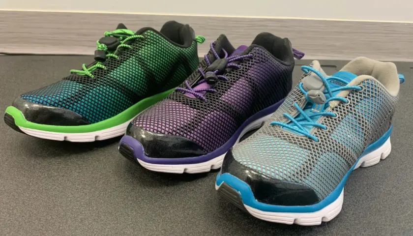 Trzy kolorowe buty sportowe z siateczką i sznurówkami. Idealne, gdy szukasz jakie buty na płaskostopie dla dorosłego.