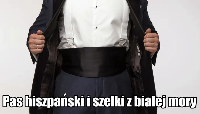 Elegancki mężczyzna prezentuje czarny pas hiszpański i białe szelki do smokingu.