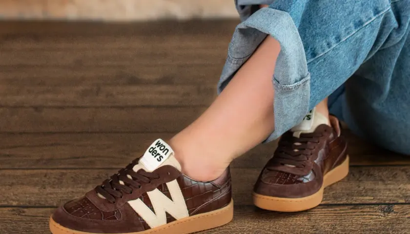 Brązowe buty damskie z krokodylim wzorem i beżowym logo "Wonders" świetnie komponują się z jeansami.