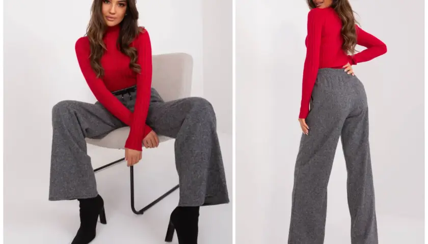 Eleganckie szerokie spodnie damskie w stylizacji z czerwonym golfem i czarnymi botkami.