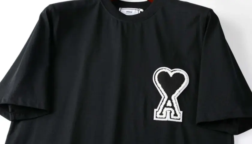 Czarna koszulka z logo serca i literą "A" od firmy AMI Paris.
