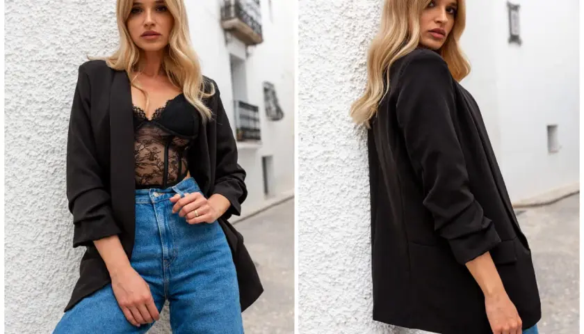 Kobieta w czarnej marynarce oversize i koronkowej bieliźnie, jeansach. Stylowe czarne marynarki oversize stylizacje.